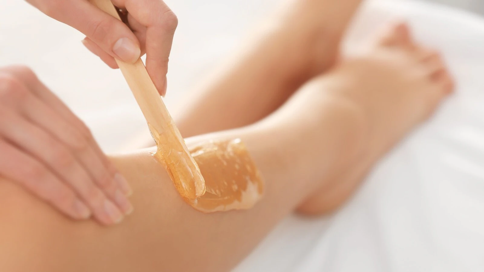 Client receiving body waxing and aftercare treatment to prevent ingrown hairs