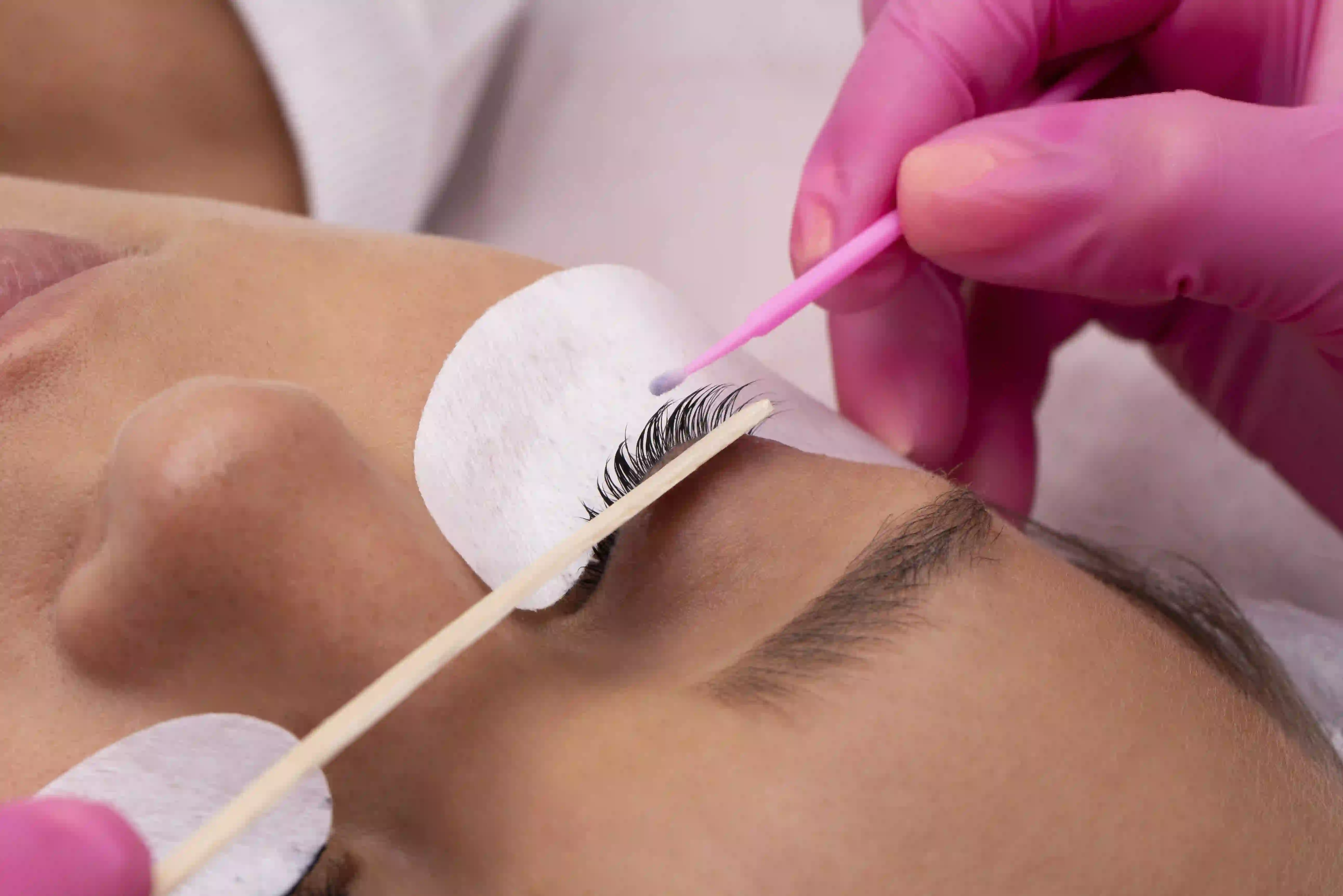 Certified esthetician applying lash lift and tint for client