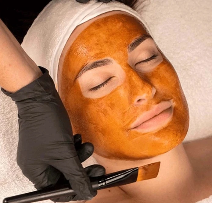 Exfoliating pumpkin facial peel treatment being applied to smooth skin texture