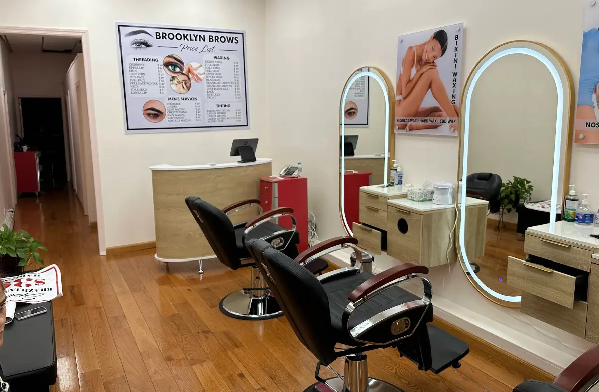 Beauty technician threading eyebrows in a modern salon